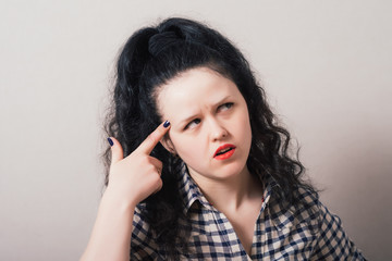 young woman thinks his finger to his temple