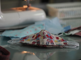 Woman use sew machine to sewing face medical mask protective against during the dust PM 2.5, coronavirus Epidemic, virus covid-19 work Home at home made DIY