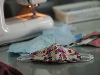 Woman use sew machine to sewing face medical mask protective against during the dust PM 2.5, coronavirus Epidemic, virus covid-19 work Home at home made DIY