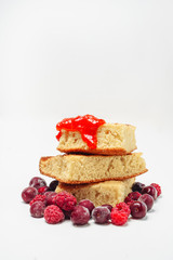Semolina cake with raspberries cherries and strawberry jam isolated on white background