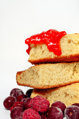 Semolina cake with raspberries cherries and strawberry jam isolated on white background