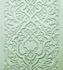 Green ceramic tile with floral pattern for wall and floor decoration. Concrete stone surface background. Texture with ornament  for interior design project.