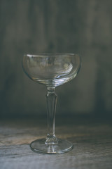 Empty coupe glass on vintage background