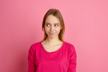 Fototapeta premium Smiling, looking at side. Caucasian young woman's portrait isolated on pink studio background, monochrome. Beautiful female model. Concept of human emotions, facial expression, sales, ad, trendy.