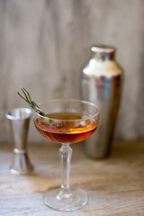 alcohol whiskey cocktail in a coupe glass with lemon and shaker