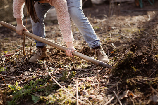 Caucasian man with shovel digs ground in garden