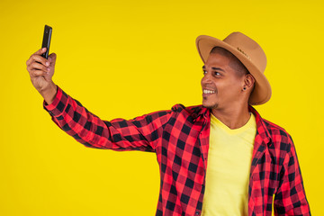 Smart casual man using smartphone in studio yellow background