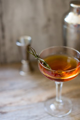 alcohol whiskey cocktail in a coupe glass with lemon and shaker
