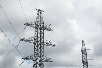 Poles of power lines between cities. Power line support against the sky.