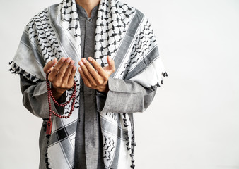Obraz premium gesture of hand open arm while pray in islamic culture carrying prayer beads over white background
