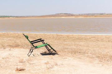 empty deck chair on the promenade, deck chair on the sandy beach