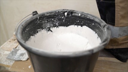 Bucket and mortar. Black bucket with white putty.