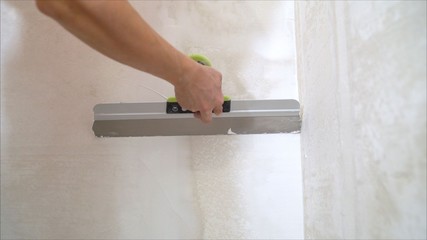 plaster on a wall. Worker plastering the walls with a spatula.