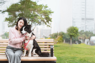 Obraz premium Girl and a Border Collie sitting on a park bench
