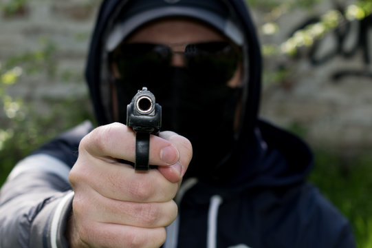 Man in a black mask with a gun