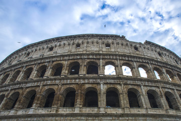 Fototapeta na wymiar Colosseum in Rome, Italy. Ancient Roman Colosseum is one of the main tourist attractions in Europe. People visit the famous Colosseum in Roma center. Scenic view of Colosseum ruins.
