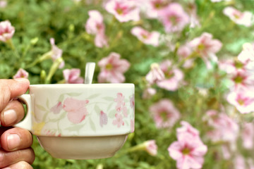 Cup of coffee with flowers in garden