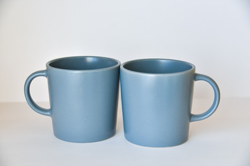 two coffee cups on a white table in a bright kitchen