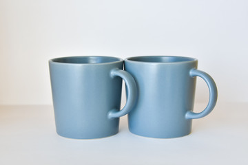 two coffee cups on a white table in a bright kitchen