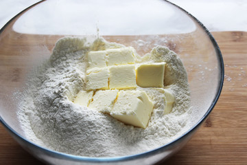 Flour and butter cubes in a large glass bowl. Homemade cake. Housework.