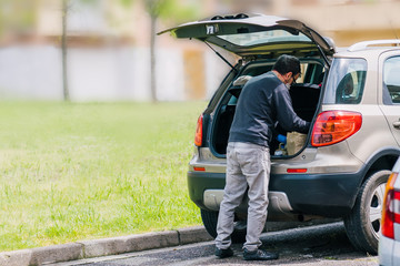 Person returning from shopping with the car wearing blue latex gloves as a measure of protection...