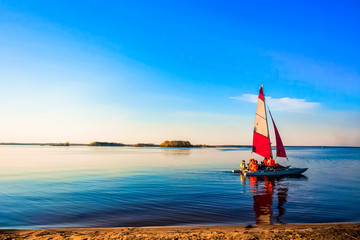 Yachting under sail . A sailing yacht with red sails floats on the river to meet adventures