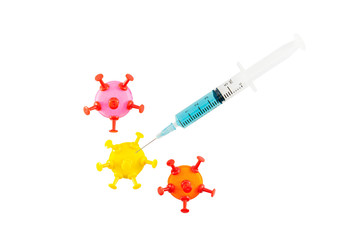 Coronavirus vaccine. Syringe injected into coronavirus model made from modelling clay and pin...