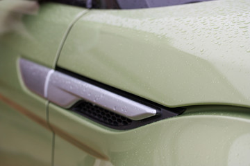 Close up of rain drops on modern green vehicle