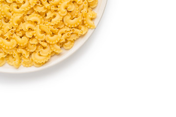 a lot of dry unprepared pasta - cockerels on a beige plate on a white background, copy space for text