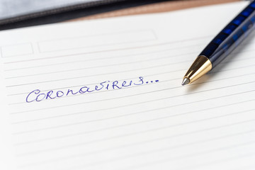 Coronavirus Covid-19 text written on empty sheet in a daily planner.