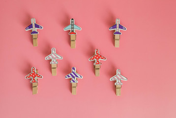 Pink background. Clothespins for photos in the form of an airplane lie on a pink background.