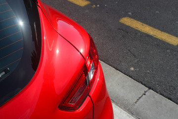 Detail of red car parked next to the road