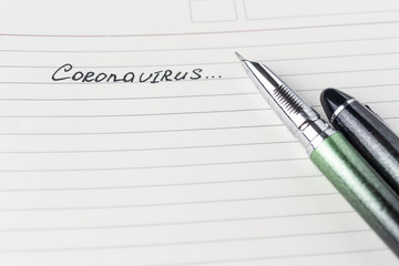 Coronavirus Covid-19 text hand-written on empty sheet in a daily planner.