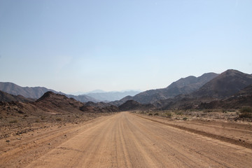 Naklejka premium Dirt road to the mountains