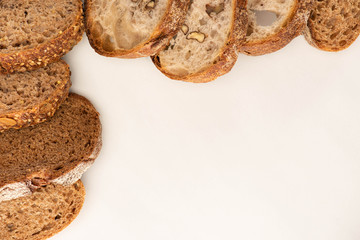 top view of fresh whole wheat bread slices on white background with copy space