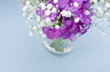 Purple blue and white flowers in a vase. High angle view with shallow DOF and copy space. Can be cut into a banner.
