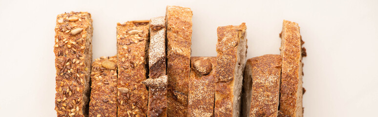 top view of tasty whole wheat bread slices on white background, panoramic shot
