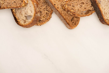 top view of fresh whole grain bread slices on white background with copy space