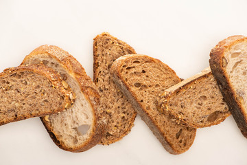 top view of fresh whole grain bread slices on white background