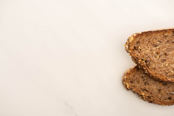 top view of fresh brown bread slices on white background