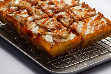 sliced detroit pizza on an iron tray