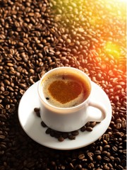 A cup of fresh coffee and coffee beans on the desk