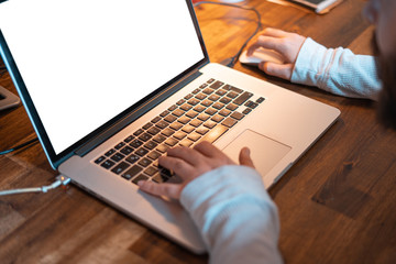 Hands pictured on the keyboard of a laptop typing something. 