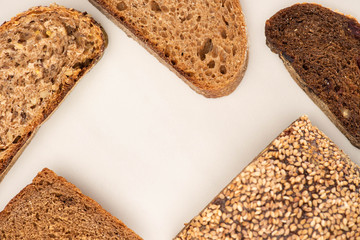 top view of fresh whole wheat bread slices and loaf on white background