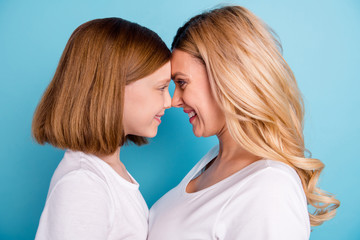 Obraz na płótnie Canvas Cloeup profile photo of two people beautiful mommy lady small little daughter blonds look eyes leaning head to head wear casual white s-shirts isolated blue color background
