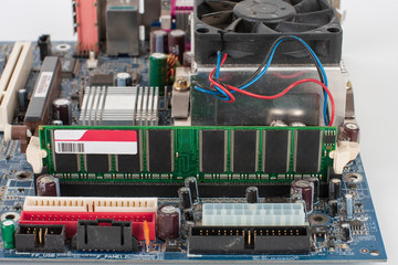Main board of old desktop computer, close up of  memory module in slot on motherboard.