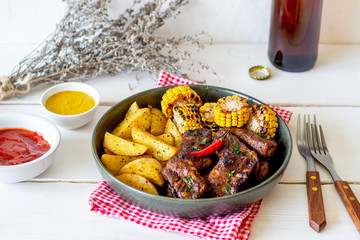 Pork ribs with potatoes on a wooden background. Barbecue. Grill. American cuisine. Recipe.