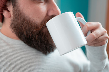 young designer with hipster style beard drinking coffee