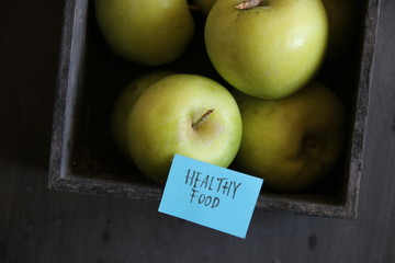 Healthy food concept. Apples in a crate. And the tag with the inscription.