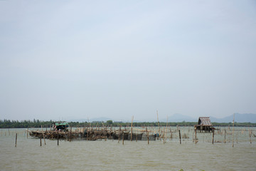 Fototapeta na wymiar View landscape with boat floating and fish cage in songkhla lake at Ko Yo Island in Songkhla, Thailand